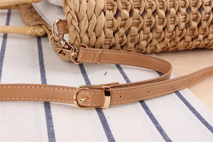 Detailed close-up of handmade paper rope beach bag with adjustable leather strap and gold hardware