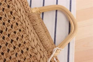 Close-up of handmade paper rope woven beach bag with natural bamboo circular handle