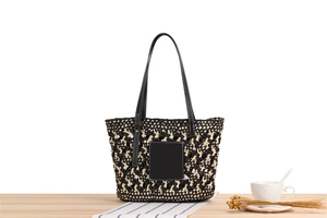 Detail of hand-woven paper rope beach bag with contrast black and white patterns