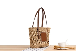 Detailed close-up of handmade woven beach bag with premium leather handles and patch