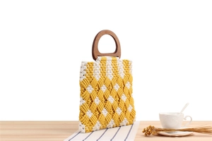 Detailed close-up of woven yellow and white checkered cotton bag with wooden handle