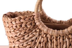 Close-up of hand-woven corn husk basket showing intricate texture and brown fabric lining