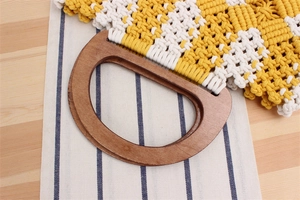 Close-up of D-shaped wooden handle and woven yellow plaid cotton rope handbag
