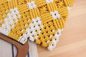 Detail of checkered macramé handbag with woven cotton rope and circular wooden handles