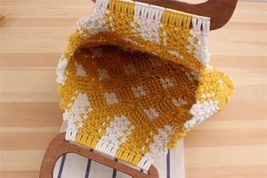 Detail of hand-woven cotton rope tote with yellow diamond pattern and wooden handle