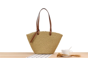 Detail of handwoven paper rope tote bag with wavy edge and brown leather handles