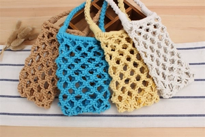 Detail of handcrafted macrame woven cotton crossbody bags in four different colors