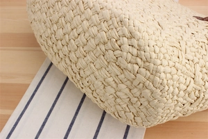 Close-up of beige woven paper rope beach bag showing detailed fiber texture and pattern