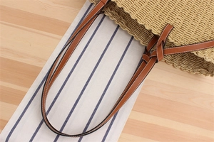 Detail of paper rope woven tote with brown leather handles and wavy edge texture