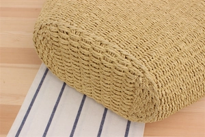 Detailed close-up of woven paper rope texture and sturdy bottom on a khaki beach shoulder bag