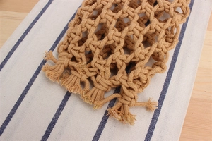 Close-up of khaki macrame woven cotton rope pattern with handcrafted net texture