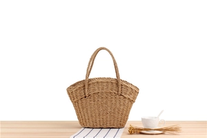 Detailed macro view of a natural paper rope woven tote bag on a rustic wooden table