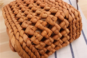 Macro detail of hand-woven straw crossbody bag with thick brown fiber texture