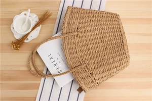 Close-up of hand-woven straw tote bag with intricate texture for beach vacation style