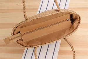 Detail view of woven paper rope bag featuring tan fabric lining and a metal zipper closure