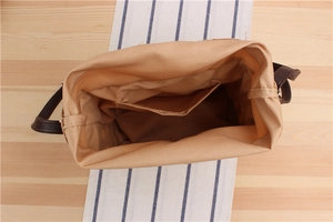 Internal view of dark brown leather crossbody bag with beige fabric lining and slip pocket