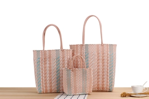 Detailed set of three striped plastic woven tote bags in pink, white, and light blue colors