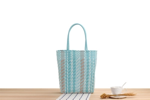 Detail of blue and pink striped woven tote bag showing plastic waterproof texture and handle