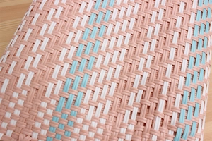 Close-up of pink, blue, and white diagonal woven plastic texture on a shopping bag