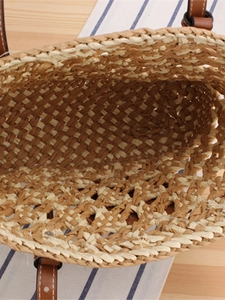 Handwoven two-tone paper straw beach bag with brown leather handles and rustic texture