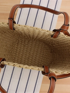 Large paper straw woven tote bag with brown leather handles and spacious interior