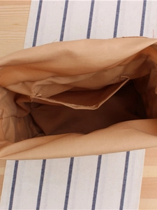 Spacious interior of a khaki woven crossbody bag with inner pocket and fabric lining