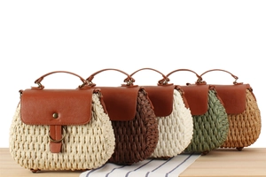Detail of five handmade straw handbags with leather flaps and metallic ring accents
