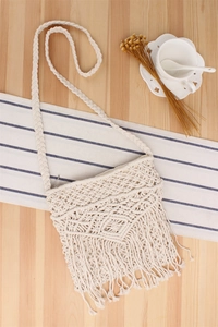 Detailliertes Macramé-Webmuster und dicke Baumwollquasten an einer beigen Boho-Umhängetasche