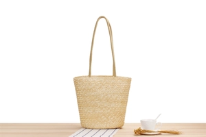 Close-up of natural woven straw bag texture and thin round shoulder strap for summer