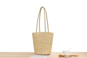 Detail of hand-woven straw tote bag on a wooden table with casual vacation vibes
