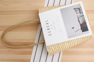 Detailed close-up of the woven straw texture and rope handles on a stylish summer beach bag