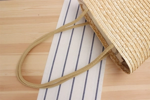 Top view of large straw beach bag featuring woven rope handles and a secure zipper closure