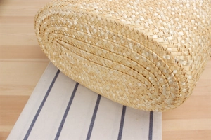 Close-up of tight spiral weave pattern on the oval base of a handmade straw beach bag