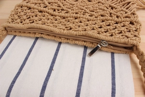Detail der gewebten Strohtasche mit Metallreißverschluss und blau gestreiftem Futter