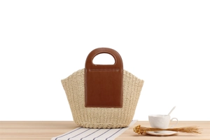 Detail of paper rope woven texture and brown leather handle with white stitching