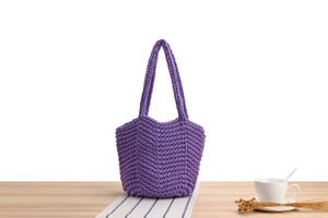 Detailed close-up of purple hand-woven crochet bucket bag with thick knit V-pattern texture