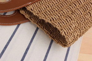 Detailed macro of woven paper straw texture and leather handle with white stitching
