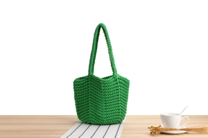 Detailed view of emerald green handmade knitted bucket bag with a textured crochet finish