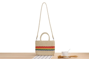 Detail of colorful rainbow stripes on a beige paper rope woven bag with wooden base