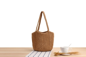 Detailed knit texture of a handmade cotton rope bucket bag on a minimalist wooden table