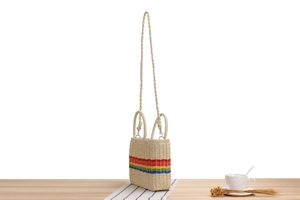 Detail of handmade woven paper rope bag with rainbow stripes and curved handles