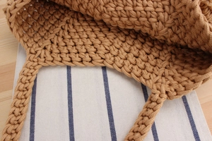 Detail shot of a dark brown hand-woven cotton bucket bag with thick rope texture