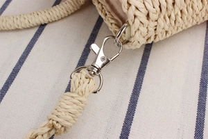 Detailed close-up of a woven paper rope bag featuring a shiny silver metal lobster clasp