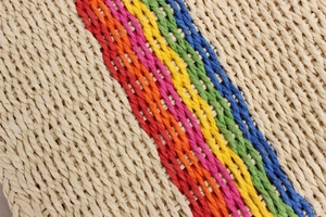 Macro detail of rainbow striped paper rope weave on a summer beach crossbody handbag