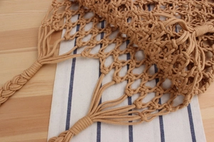 Detail of hand-woven cotton mesh bag featuring intricate hollow weave texture in tan
