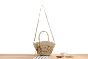Détail du sac cabas en paille tissé main avec breloque perle à franges et texture