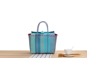 Close-up of hand-woven plastic picnic basket showing textures and button closure