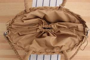 Vue de dessus d'un sac en paille tressée montrant la doublure et le cordon
