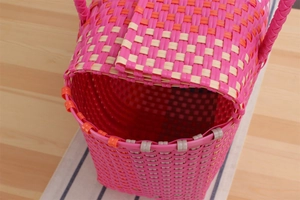 Interior view of handwoven pink and orange plastic basket with sturdy handles