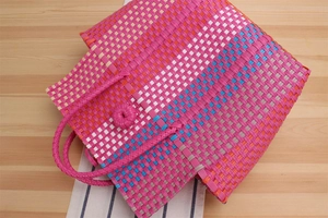 Close-up of colorful hand-woven plastic beach bag with durable textured pattern